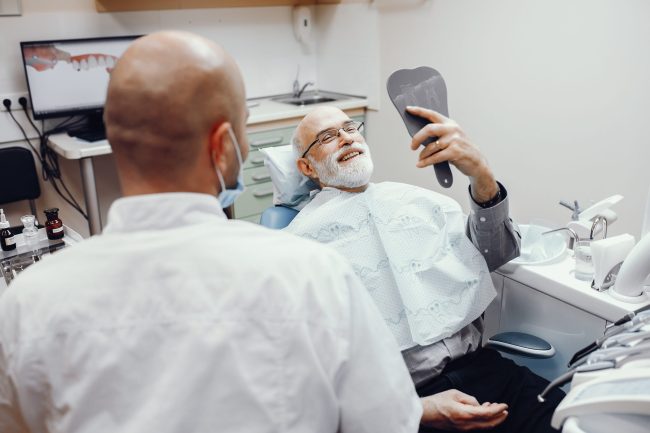 Old man sitting in the dentist’s office طب الأسنان التجميلي لكبار السن - مركز وندرز لعلاج الاسنان